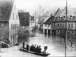 Menschen werden in einem Kahn durch die überschwemmte Stadt gefahren