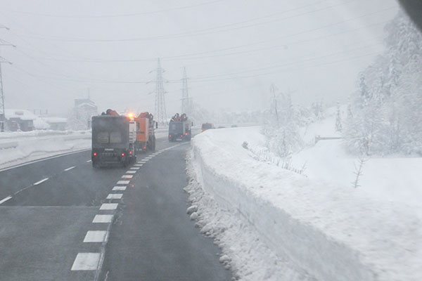 Foto aus dem Führerhaus mit Schneemassen an der Straße.
